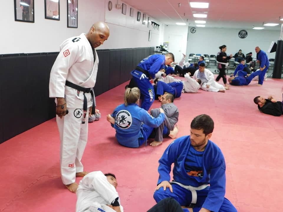 Professor Gideon Ray watching over students as they drill techniques during an adult Brazilian Jiu Jitsu class.