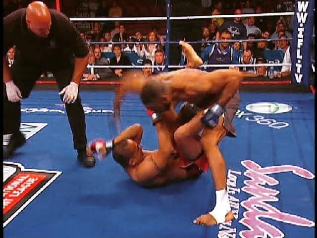 Gideon Ray competing in an International Fight League bout, fighting from the ground as the referee looks on.